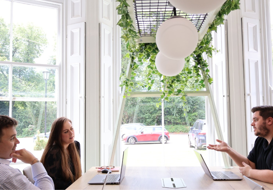 three people sat around the table laughing